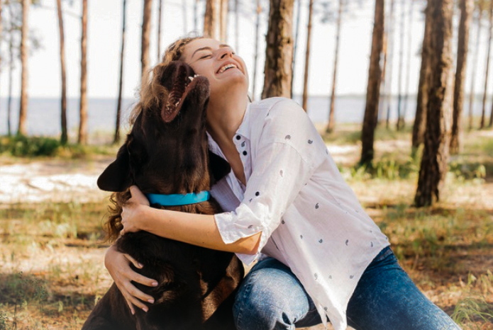 Woman hugging brown dog