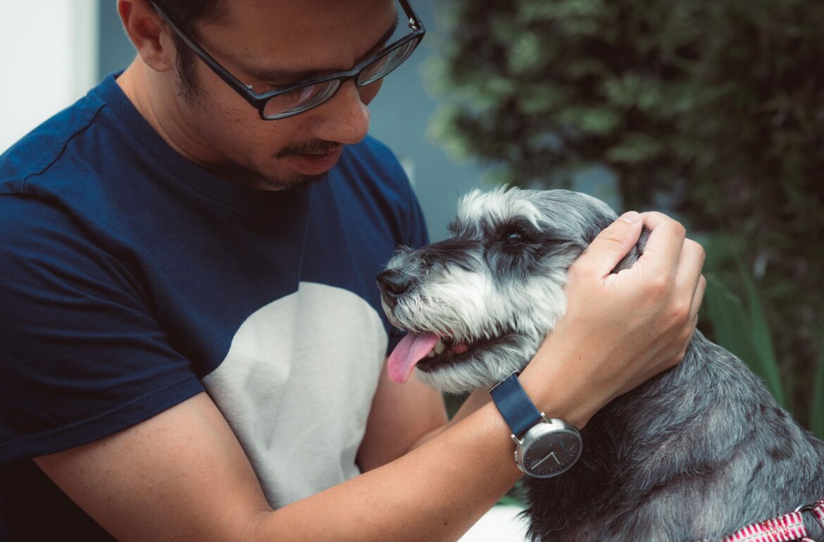 Man scratching a dog behind ear