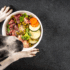 Dog looking upwards with a bowl of raw dog food containing offal organ meat