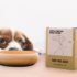 Dog peering over table with The Grateful Pet's cage-free duck for dogs